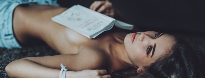مدل اینستاگرام دراز کشیده روی مبل با کتاب